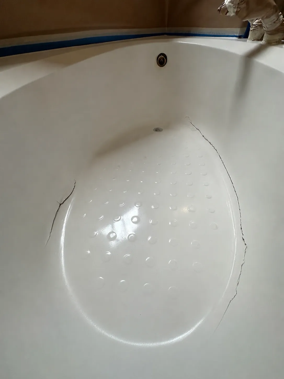 Cracked fiberglass bathtub floor before repair in Austin.