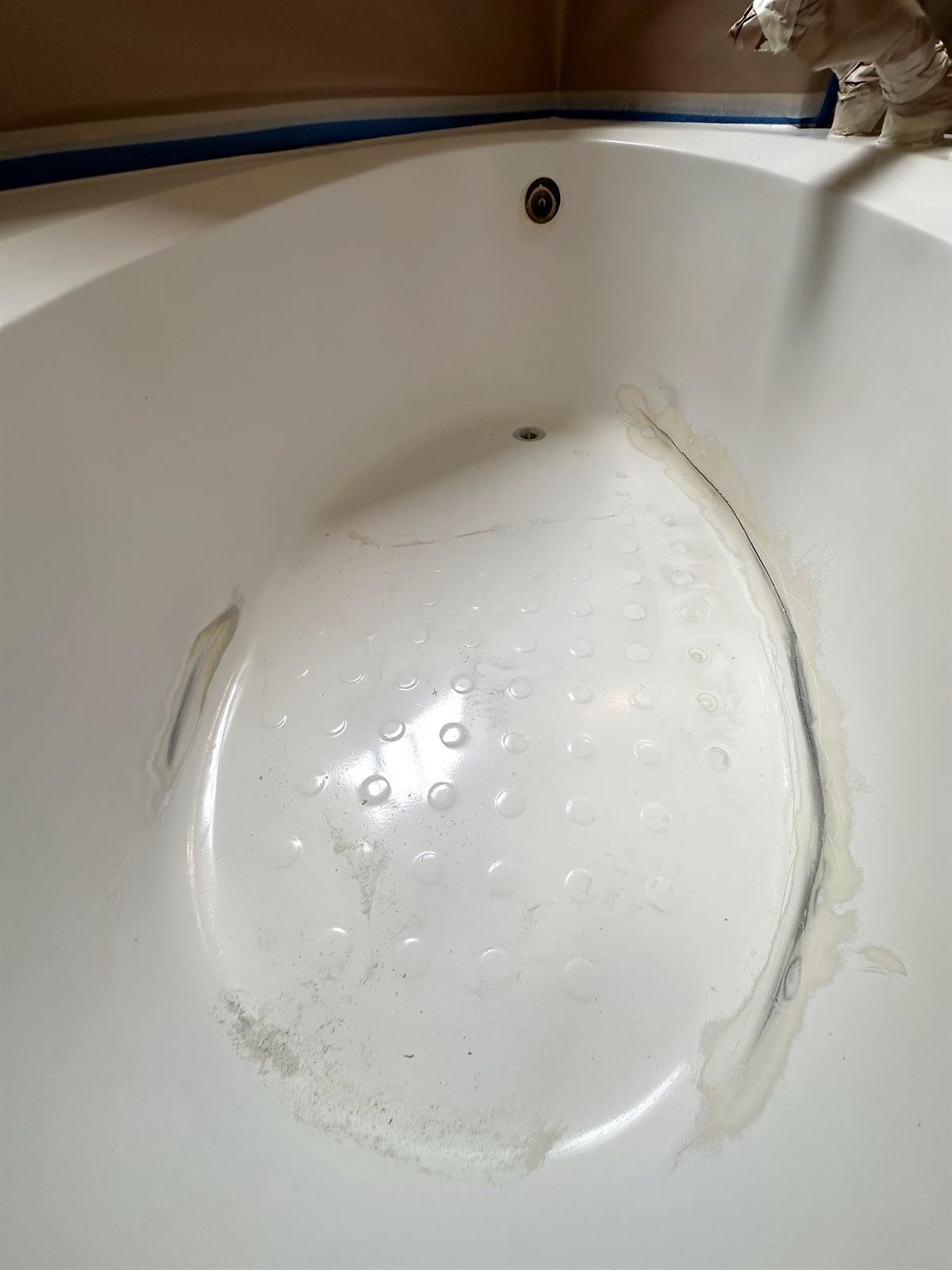 Before bathtub refinishing photo with peeling surface near shower wall