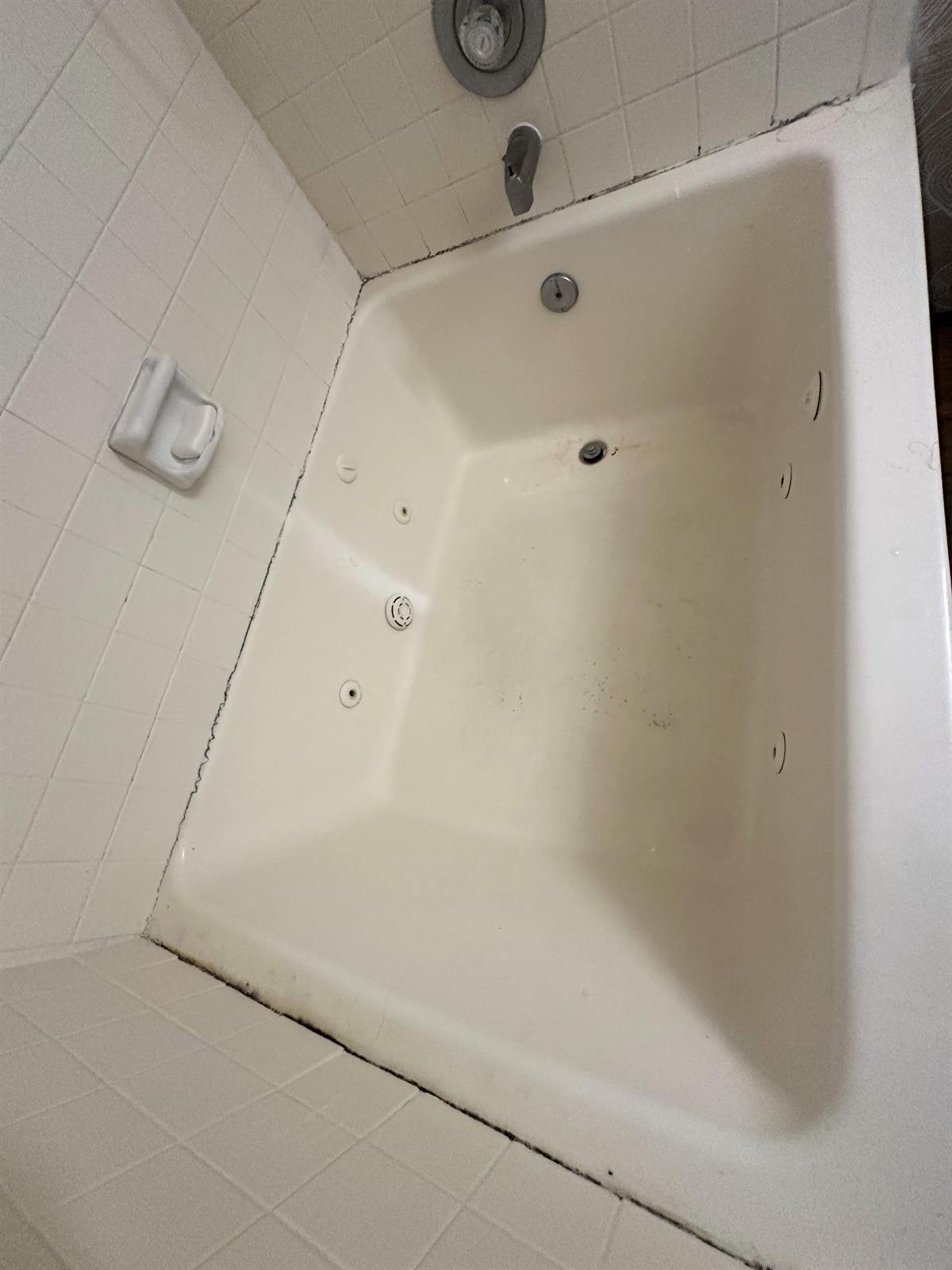 Before whirlpool tub repair showing worn non-slip area and surface damage