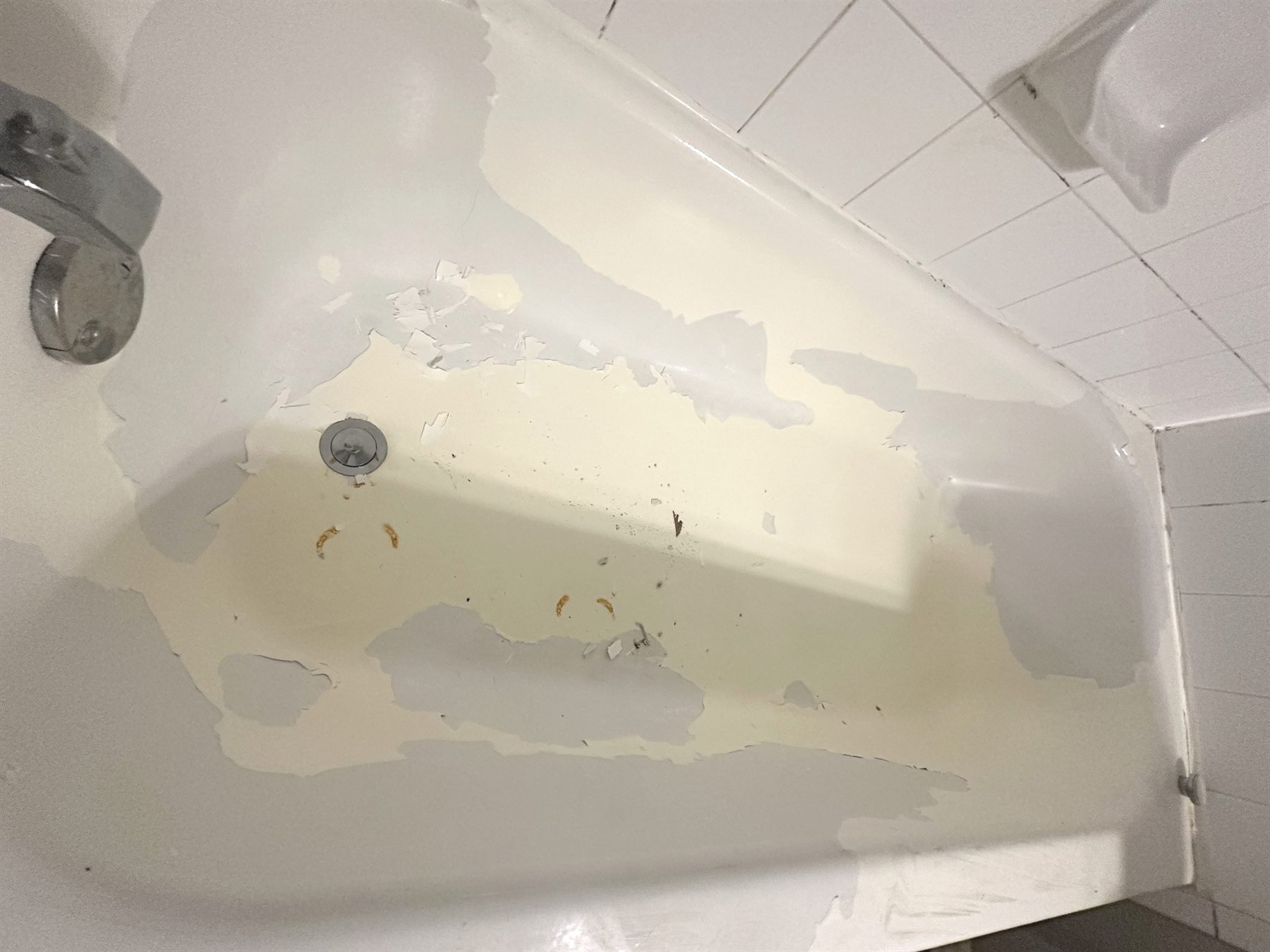 Peeling reglazed bathtub in Austin with failed bathtub refinishing coating